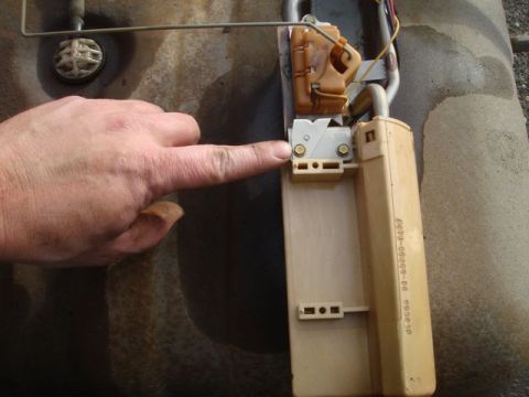 1996 Ford Bronco - A person's finger points to the electrical contacts on a fuel pump sending unit / fuel level sender assembly removed from a fuel tank, show…