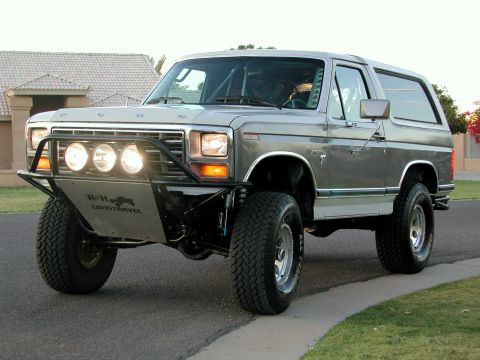 1980 Ford Bronco - This modified 1980 Ford Bronco features a custom front bumper with auxiliary lights and a roll cage visible inside.