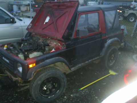 2001 Ford F-350 - Suzuki Samurai with hood open, parked outdoors with a broom nearby.