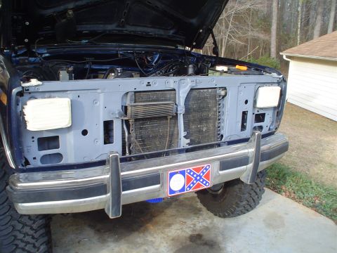 1984 Ford Bronco - SUV front end with hood open, revealing the engine bay and radiator assembly.