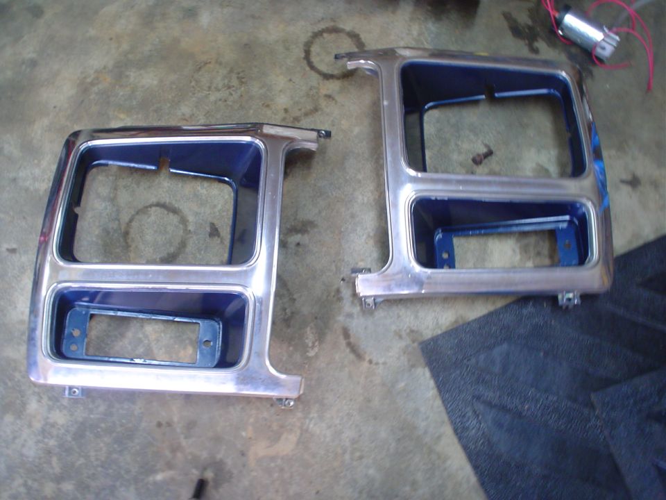 Two chrome headlight bezels with blue backing, likely for an older truck or SUV