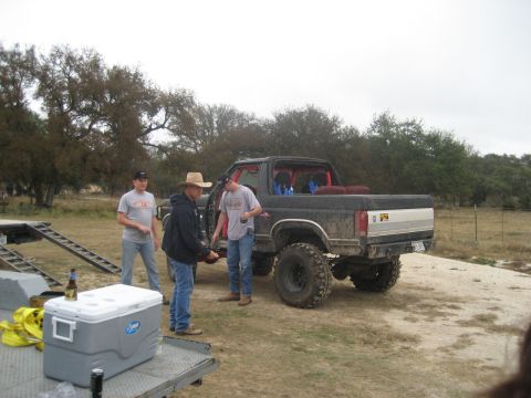 2001 Jeep Wrangler - A group of men stand around a lifted black Ford Bronco in an outdoor, grassy area.