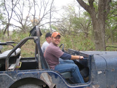 2001 Jeep Wrangler - Two men are riding in a blue Jeep Wrangler in a wooded area.