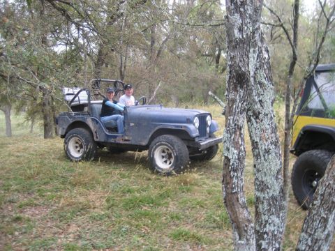 2001 Jeep Wrangler - A blue Jeep CJ-5 is parked on a grassy field with another Jeep partially visible to the right.