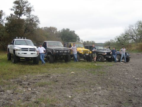 2001 Jeep Wrangler - A group of friends and their off-road vehicles pose for a photo in a muddy field.