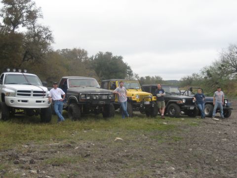 2001 Jeep Wrangler - A group of friends and their modified off-road vehicles gathered outdoors on a cloudy day.