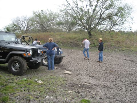 2001 Jeep Wrangler - Two Jeep Wranglers are parked on a dry, cracked ground with people observing the surroundings.