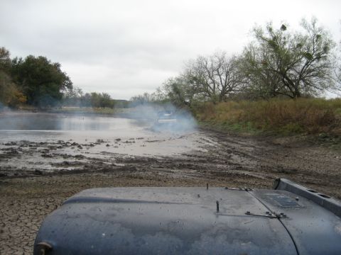 2001 Jeep Wrangler - Two Jeep Wranglers navigate a muddy, off-road course under an overcast sky.