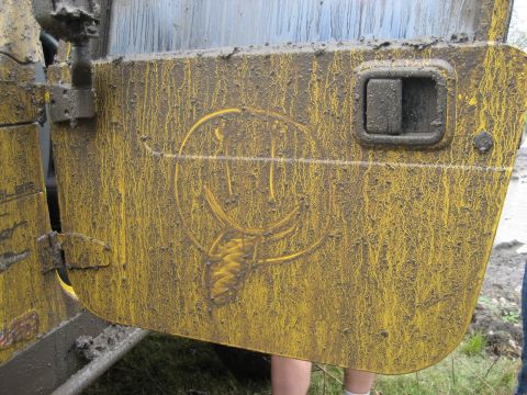 2001 Jeep Wrangler - A mud-caked yellow Jeep door displays a smiley face graphic, indicating off-road use.
