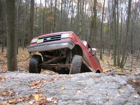 1990 Ford Bronco - This 1990 Ford Bronco navigates a rocky trail in a forest setting.