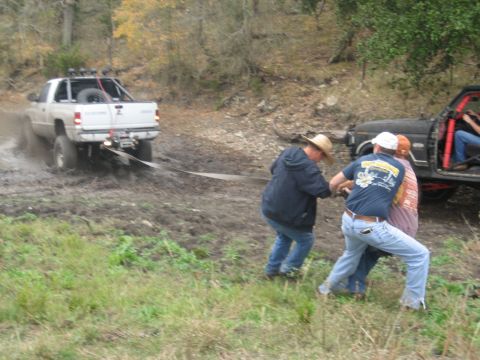 2001 Jeep Wrangler - Two vehicles are stuck in the mud, with people attempting to free one of them.