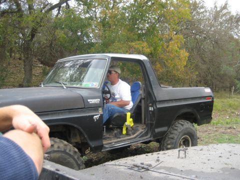 2001 Jeep Wrangler - A man sits in the driver's seat of a black Ford Bronco, which appears to be from the late 1970s.