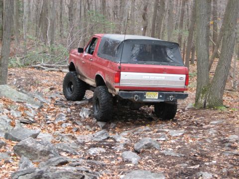 1990 Ford Bronco - This 1990 Ford Bronco navigates a rocky, wooded trail with its soft top in place.
