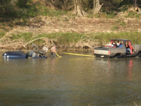 2001 Jeep Wrangler - A truck is in the water, towing a submerged vehicle out of the river.