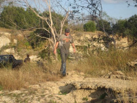 2001 Jeep Wrangler - A man walks through a dry, overgrown area with a pickup truck visible in the background.
