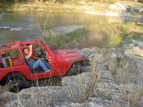 2001 Jeep Wrangler - Off-roading in a red Jeep Wrangler near a river.