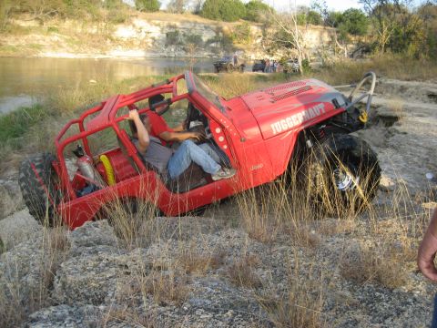 2001 Jeep Wrangler - This modified 2001 Jeep Wrangler, labeled "JUGGERNAUT", tackles a challenging off-road course near a river.