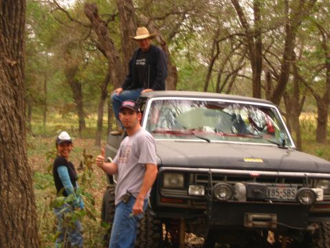 2001 Jeep Wrangler - A black Jeep with a winch and brush guard is parked in a wooded area with three people around it.