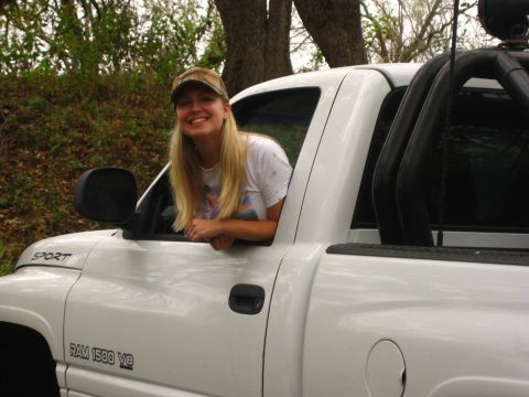 2001 Jeep Wrangler - A woman in a baseball cap smiles as she leans out the window of a white Dodge Ram 1500 V8 pickup truck.