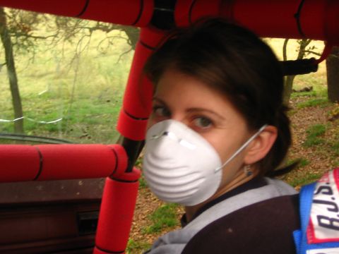 2001 Jeep Wrangler - A woman wearing a dust mask looks over her shoulder from inside a vehicle with red padded roll bars.