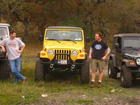 2001 Jeep Wrangler - A yellow 2001 Jeep Wrangler is parked outdoors with two men standing nearby and another Jeep to its right.