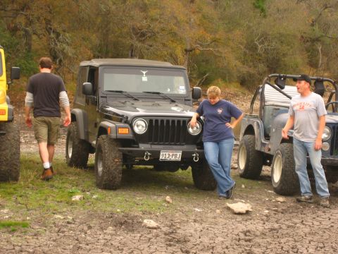 2001 Jeep Wrangler - Three Jeep Wranglers are parked off-road with people standing around them in a natural setting.