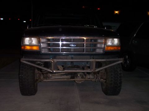 1995 Ford Bronco - The front of a Ford truck is shown at night, a custom bumper and grille.