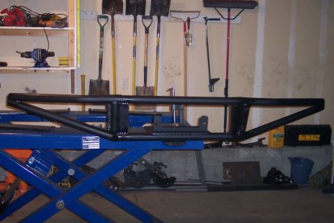 1995 Ford Bronco - Aftermarket bumper part shown on a lift in a garage setting.