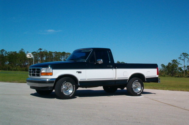 1995 Ford F-150 pickup truck, two-tone black and white paint, parked on pavement