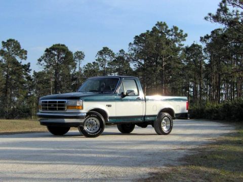 1995 Ford F-150 - Two-tone 1995 Ford F-150 pickup truck parked on a dirt road.