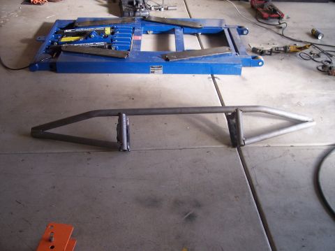 1995 Ford Bronco - A custom fabricated metal bumper is shown on a concrete floor, with a vehicle lift in the background.