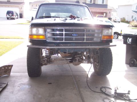 1995 Ford Bronco - Front view of a black Ford Bronco with modifications to the bumper and suspension.