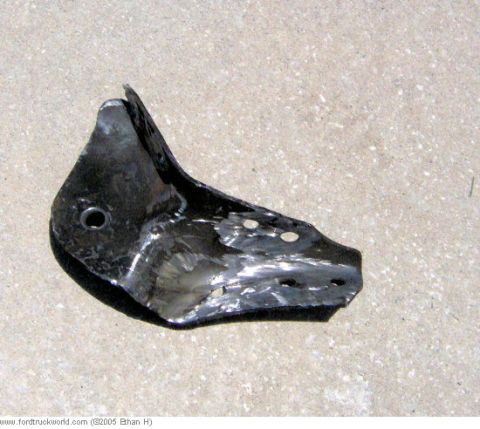 1995 Ford F-150 - This is a bent metal suspension bracket with multiple holes and weld marks.