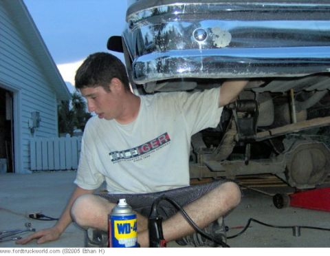 1995 Ford F-150 - Man works on the rear suspension of a 1995 Ford F-150, with a can of WD-40 nearby.