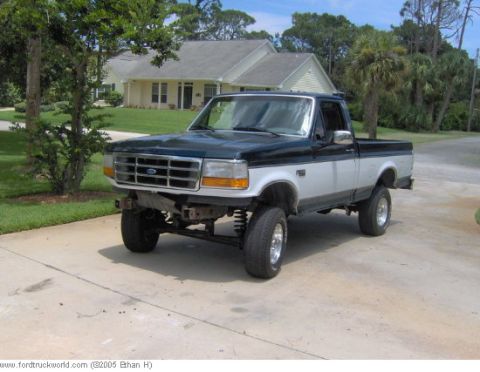 1995 Ford F-150 - A lifted Ford F-150 pickup truck is shown from a three-quarter front angle on a sunny day.