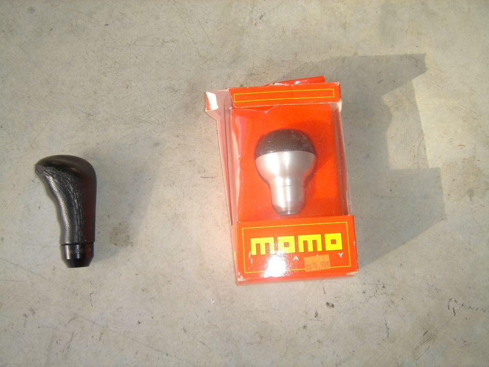 Black shift knob beside a boxed MOMO shift knob
