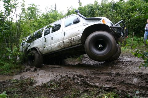 2000 Ford E350 - Modified 2000 Ford E350 van tackling a challenging muddy off-road course.