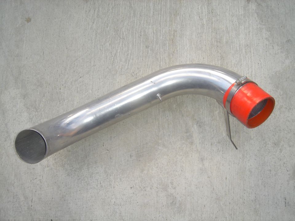 Polished metal intake pipe with red coupler on concrete