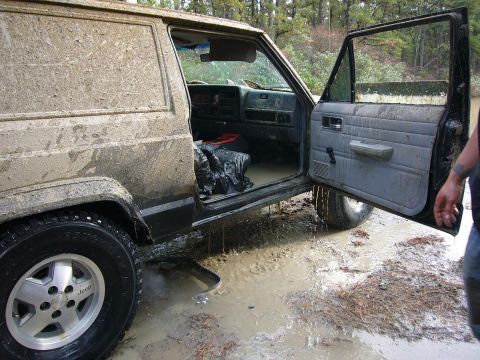 1989 Jeep Cherokee - This mud-covered Jeep Cherokee appears to be from the mid-1980s, not 1989, and is stuck in a muddy area.