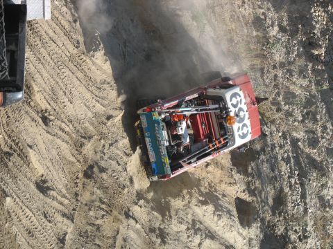 1987 Ford Bronco - Modified truck navigating a challenging dirt terrain with dust clouds.