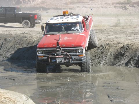 1987 Ford Bronco - This modified truck navigates a muddy obstacle course, its off-road capabilities.