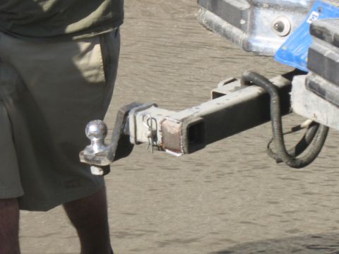 1987 Ford Bronco - Close-up of a trailer hitch receiver, showing the ball mount and a portion of the vehicle it's attached to.