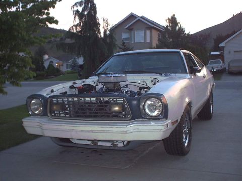 1978 Ford Mustang II - Front view of a white 1978 Ford Mustang II, hood raised to reveal the engine and aftermarket air intake.