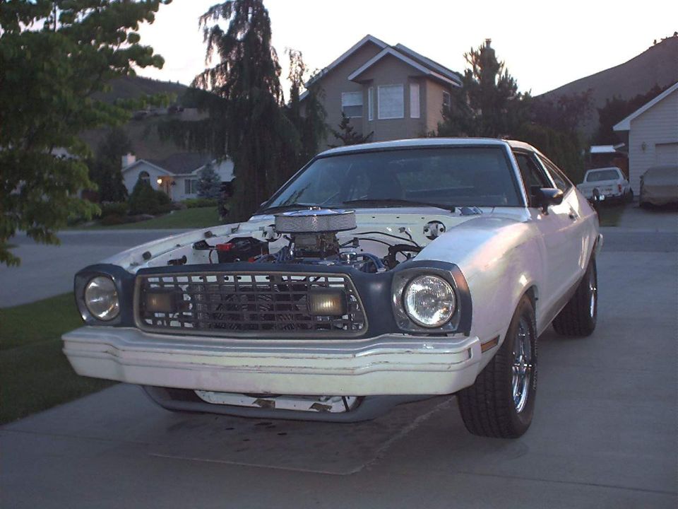 White 1978 Ford Mustang II with hood open, showing engine and chrome air cleaner