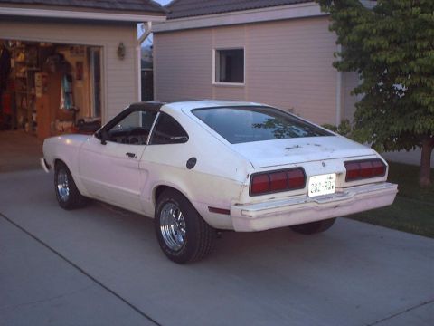 1978 Ford Mustang II - Rear view of a 1978 Ford Mustang II coupe. The car is white with a black vinyl roof and aftermarket wheels.