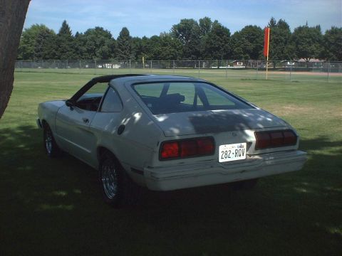 1978 Ford Mustang II - This 1974 Ford Mustang II coupe is seen from the rear, parked on a grassy field under a clear sky.