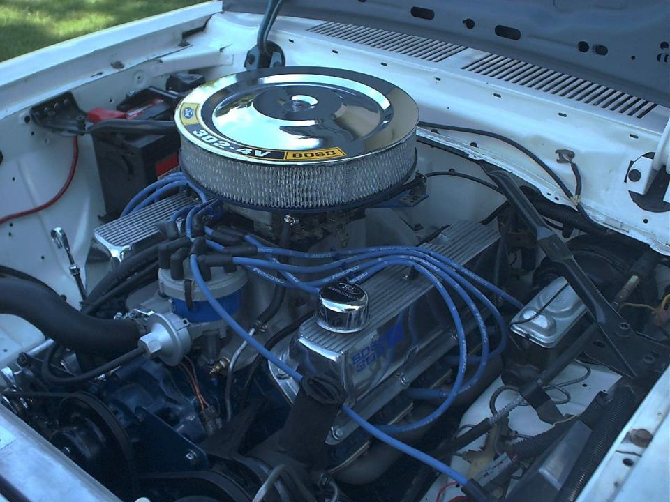 Engine bay with chrome air cleaner labeled 302-4V BOSS and chrome valve covers