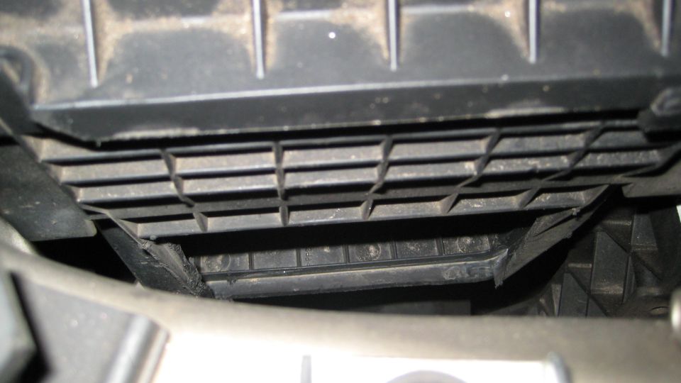 Black plastic grille with horizontal slats and a textured surface, viewed from below