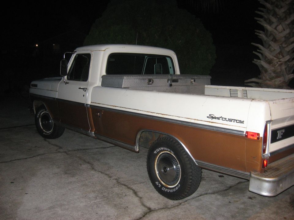 White and brown Ford Sport Custom pickup at night, rear three-quarter view with toolbox in bed