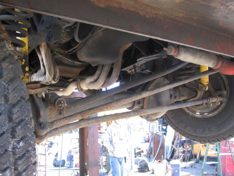 1995 Ford F-150 - Underside view of a truck's front axle and suspension system, showing various mechanical components.